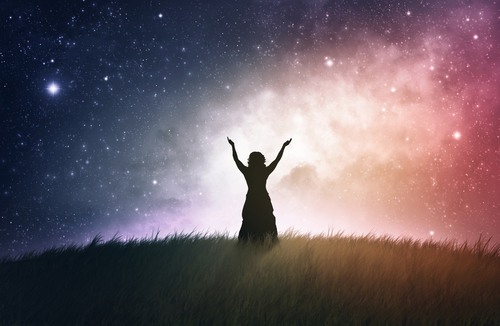 A woman lifting her hands with a space background