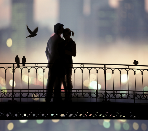 silhouette of bridge and pair of lovers on city background