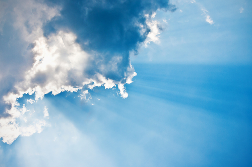 Beautiful blue sky with sunbeams and clouds