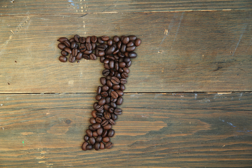 Number seven made with coffee beans on a wooden plank